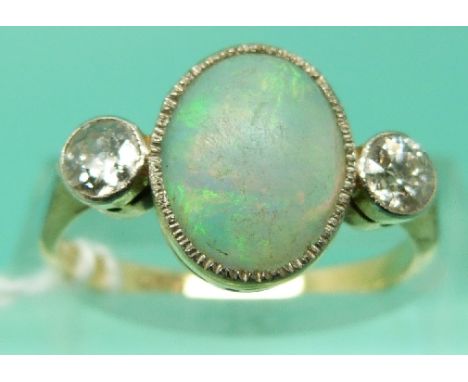 An 18ct gold ring set with an oval opal cabochon and two diamonds in a platinum setting (Size O)