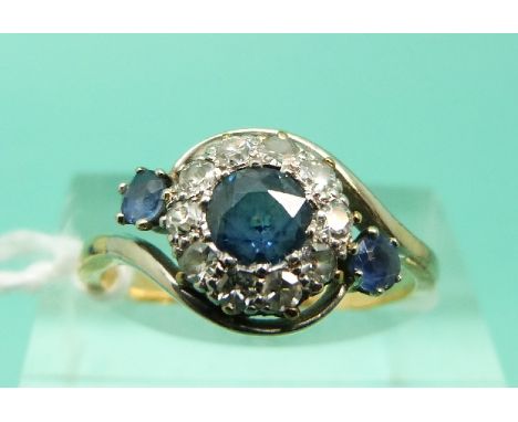 An 18ct gold ring set with three sapphires surrounded by diamonds in a platinum twist setting (Size J)