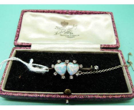 A Victorian brooch with two heart shaped opal cabochons surrounded by diamonds, in original box