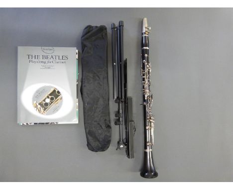 A cased Boosey & Hawkes clarinet, two books of music and a stand