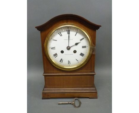 Maple & Co. inlaid mahogany clock with serpentine top, the enamel Roman dial with blue spade hands, the movement striking on 