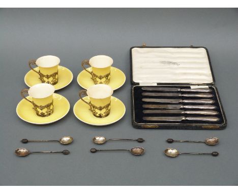 Four Aynsley cups and saucers with hallmarked silver mounts, London 1903; six hallmarked silver coffee bean spoons, and a cas