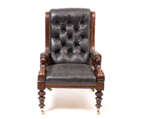 A 19TH CENTURY MAHOGANY FRAMED LIBRARY ARMCHAIR  with carved lion mask arms, black leather button upholstery and turned suppo