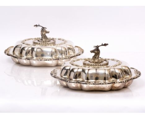 A PAIR OF SILVER PLATED ENTREE DISHES of serpentine outline, the covers with handles in the form of a crest of a stag with ne