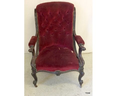 An upholstered button back armchair on casters. 98cm tall