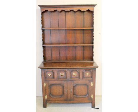 An oak dresser 4 drawer 2 door with brass furniture and a 3 shelf top 190 x 107 x 47cm