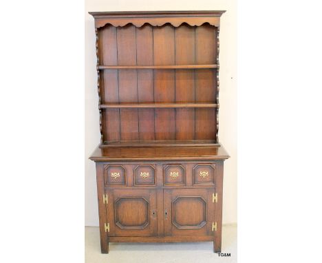 An oak dresser 4 drawer 2 door with brass furniture and a 3 shelf top 190 x 107 x 47cm