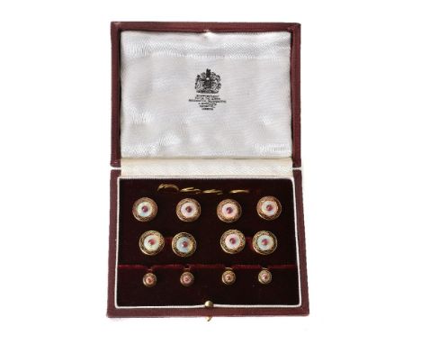 An 18 carat gold opal and ruby dress set by Asprey, the cufflinks with circular polished opal panels each centred with caboch