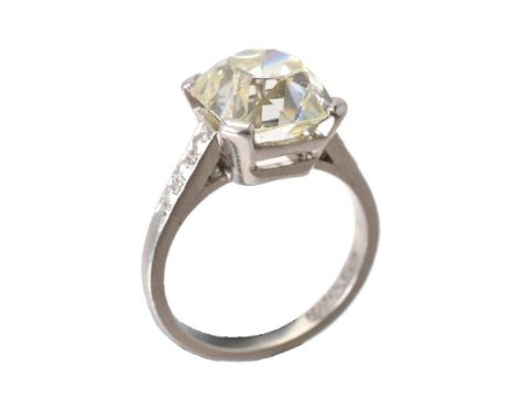 ΩA single stone diamond ring, the old mine cut diamond weighing 4.38 carats, the shoulders set with trios of eight cut diamon