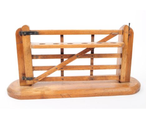 A vintage 20th century wooden novelty pipe holder in the form of a gate. Featuring six holes to hold the pipes, attached to t