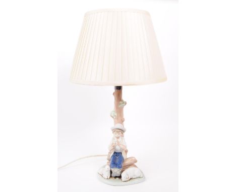Nao - A vintage 1988 Spanish porcelain table lamp, no. C10-15. Complete with shade, depicting a figure of a young boy sitting