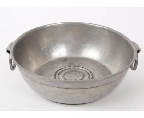 An early 20th century French pewter twin handled bowl. Having ring carry handles to side, impressed stamps to underside with 