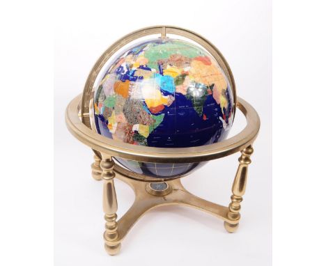 A 20th century specimen stone table top revolving globe, featuring a metal stand and compass. Measuring approx. 44cm tall.