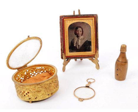 A collection of 19th century Victorian curios to include an ambrotype featuring a female sitter with rouged cheeks, a brass v