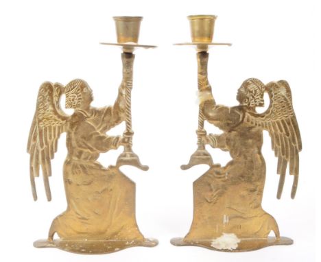 A pair of vintage 20th century brass candlesticks cast in the form of winged angels upholding candlestick basins. Measures ap