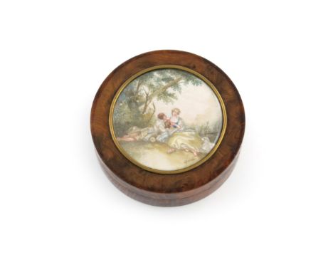 λA late-18th / early-19th century burr-walnut snuff box, circular form, the pull-of cover with a painted scene under glass of
