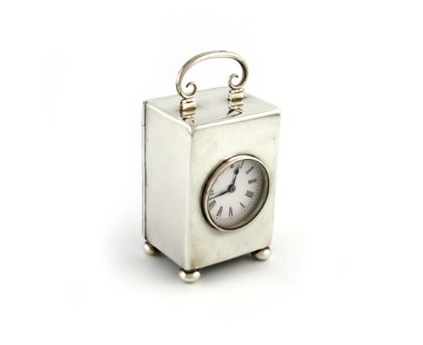 A late-Victorian silver clock, by William Comyns, London 1897, upright rectangular form, hinged scroll handle, enamel dial, o