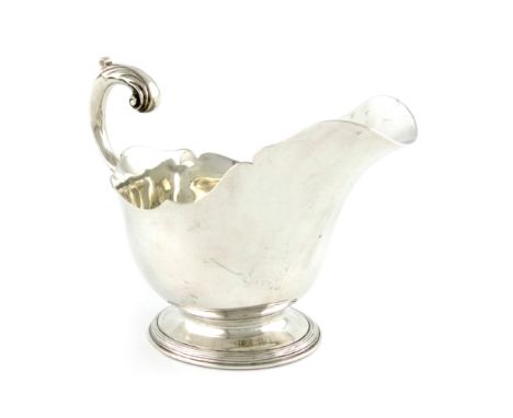 A Victorian silver sauce boat, by John Samuel Hunt, London 1860, oval form, wavy-edge border, leaf capped scroll handle, on a