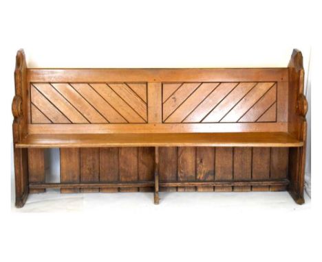 Late Victorian light oak free standing church pew, with diagonally-planked back panels between shaped ends with rosette termi