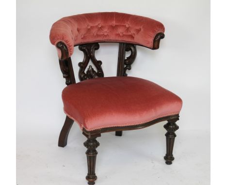 An early Victorian carved mahogany tub chair, with button upholstered curved back and seat, on turned and fluted legs, with a