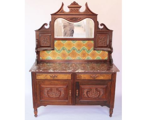 A late Victorian carved walnut marble top cabinet, with raised mirror and tile back, above a marble top, two drawers and two 