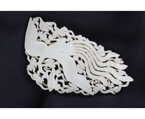 A Chinese carved jade panel, carved with a phoenix in flight, 7cm high x 13cm wide 