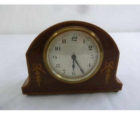 An Edwardian shaped oval mantle clock with silvered dial and Arabic numerals