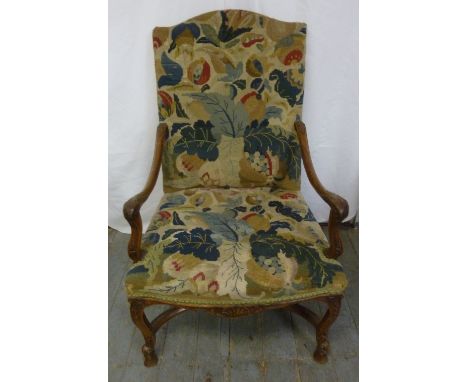 A 19th century French elbow chair with carved scrolling arms and legs and tapestry seat and back