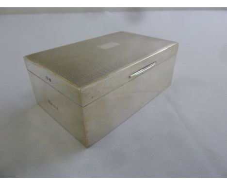 A rectangular silver engine turned cigarette box