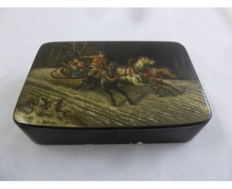 A rectangular Russian papier-mâché snuff box with hand painted image to hinged cover