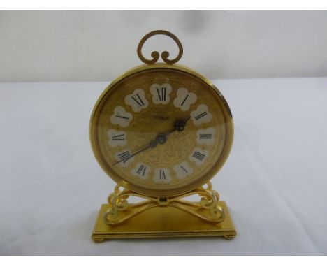 Imhof Swiss fifteen jewel 8 day gilded metal mantle clock of circular form on rectangular base