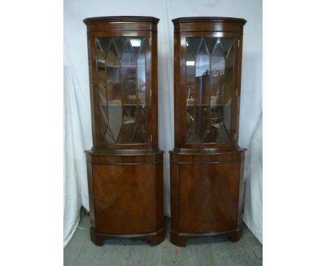A pair of mahogany glazed corner cabinets of customary form on bracket feet