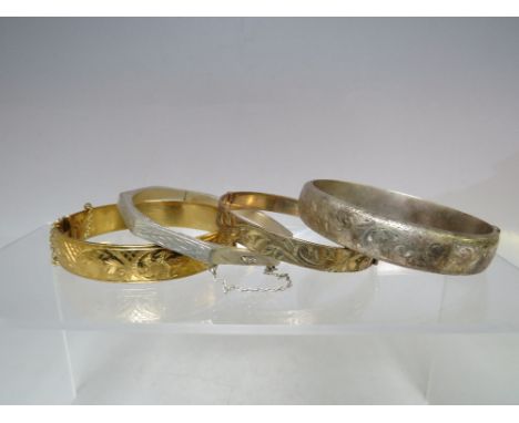 FOUR VINTAGE SILVER AND GOLD PLATED HINGED BANGLES, comprising an octagonal example marked 925, a hallmarked silver bangle, a