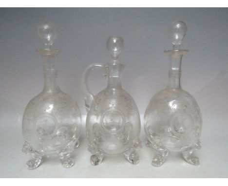 A SET OF THREE THOMAS WEBB LION MASK DECANTERS, with extensive engraved decoration throughout, to one side a family crest / c