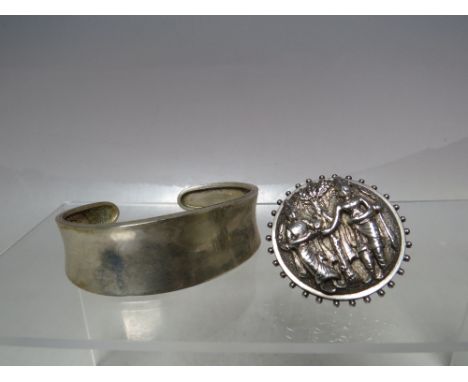 AN ORIENTAL STYLE FIGURATIVE WHITE METAL BROOCH, of circular form with raised embossed type embellishment, W 3.5 cm, together