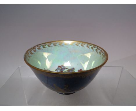 AN EARLY 20TH CENTURY WEDGWOOD FAIRYLAND LUSTRE SMALL FOOTED BOWL - PATTERN Z4829, the blue tonal exterior with gilt embellis