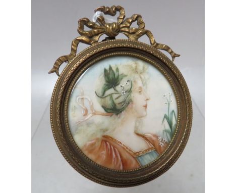 (XIX). A circular portrait miniature on ivory of a young woman, unsigned, framed in decorative brass frame with strut back an