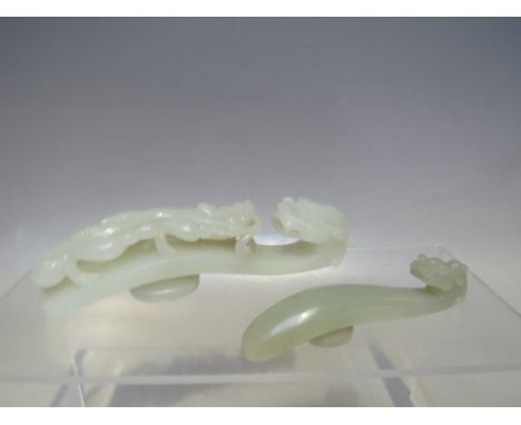 A CHINESE CARVED JADE 'DRAGON' BUCKLE / BELT HOOK, approx length 12 cm, together with a smaller example (2)