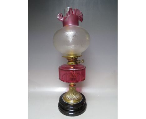 A VICTORIAN BRASS OIL LAMP, with ruby glass reservoir, etched glass shade, H 55 cm