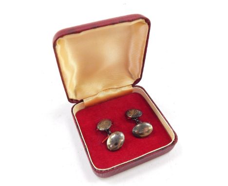 A pair of silver cufflinks, each with oval tops and chain centres, engine turned with scrolls and flowers, in a fitted case. 