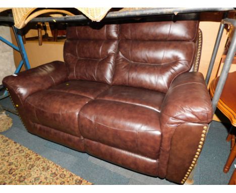 A brown leatherette two seater manual reclining sofa.