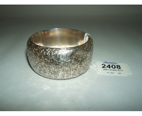 A wide unmarked silver Bangle with engraved decoration