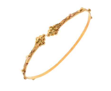 Yellow metal torc bangle, the narrow band having engraved decoration and roundels, stamped '18K', 7.4g approx