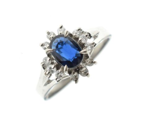 Sapphire and diamond cluster ring, the white mount stamped 'Pt 900', the oval cut sapphire enclosed by twelve brilliant cut d