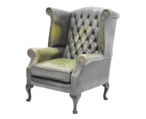 Button back green leather wingback armchair standing on cabriole front legs, 86cm wide x 94cm x 104cm high