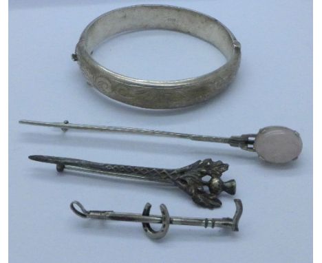 A silver bangle and three brooches