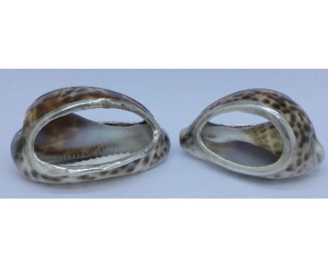 Two white metal mounted shells