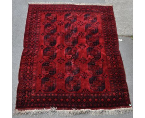 A 20th century Afghan Ersari village carpet floor rug, in the manner of Khal Mohammadi. Having a red ground, with dark blue p