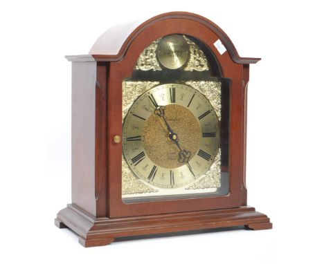 A contemporary Tempus Fugit mantel clock. Having an arched top with flared sides, gilt face on ebonised Roman chapter ring. W