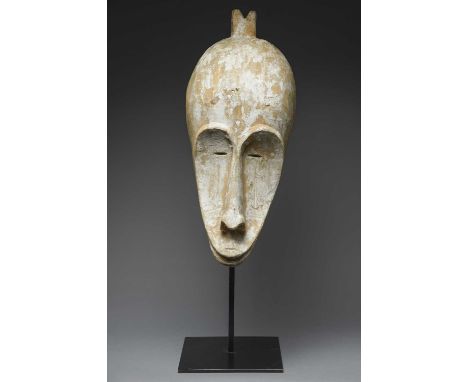 A Fang maskGabonwith a grooved crest and carved arrow symbols under the eyes, with remains of kaolin,62cm high, on a stand. (